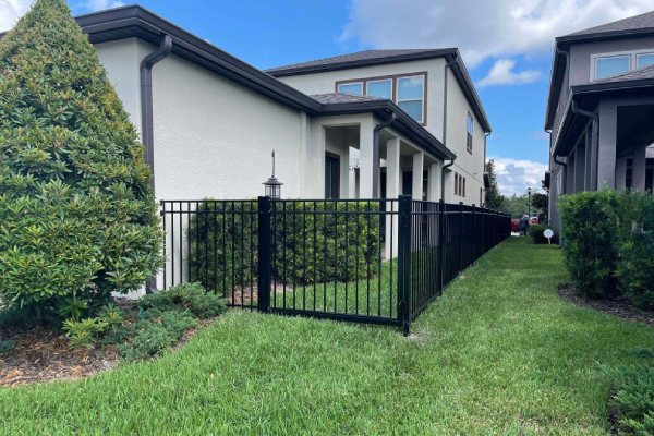 Black aluminum ornamental safety fence installation around a residential backyard and patio in Tampa