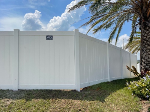 Custom white vinyl privacy fence installed along a Tampa backyard property line
